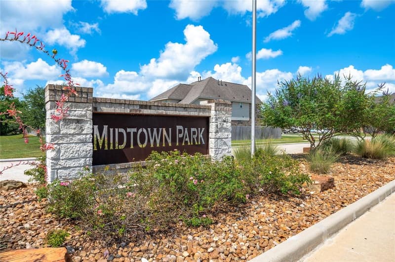 Midtown Park subdivision entrance sign in brick and stone with flowering shrubs and landscaped rock beds
