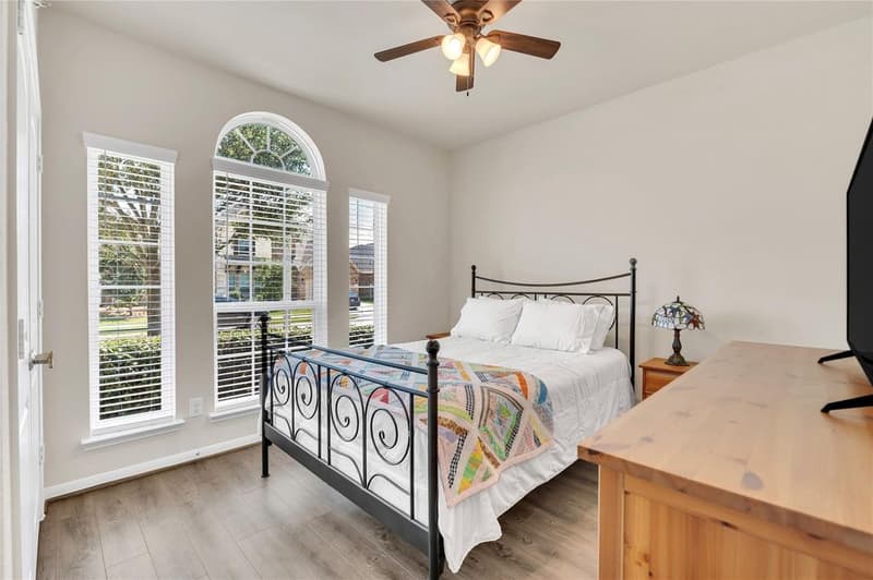 Secondary bedroom with an arched center window and two tall side windows facing the street