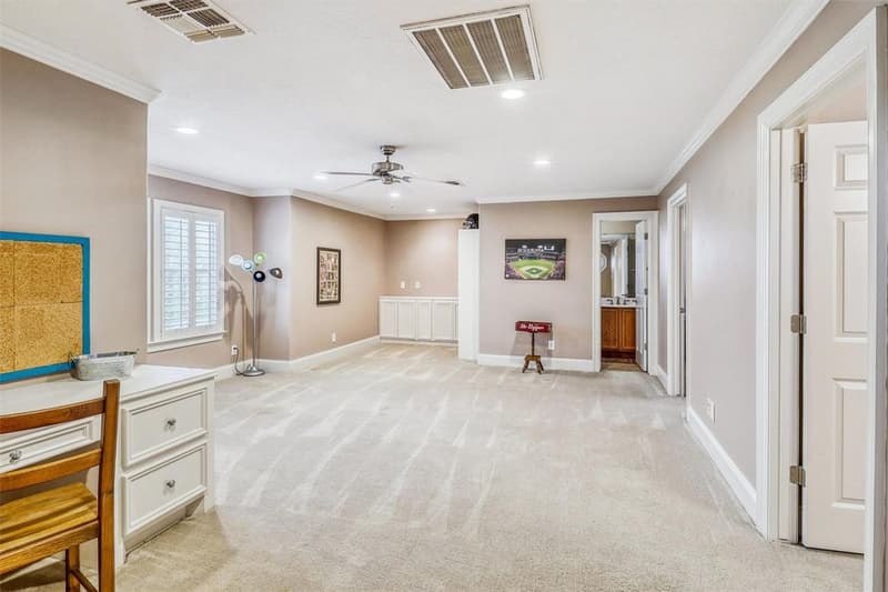 Large carpeted upstairs room with recessed lights, ceiling fan, crown molding, white built-in cabinets and several doorways