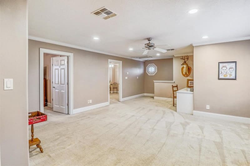 Upstairs game room with ceiling fan, recessed lights, an octagonal window and a small built-in counter