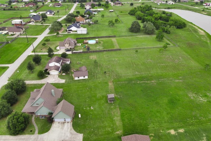 High drone view of the surrounding acreage lots, with water along the right side